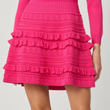Vibrant pink dress with a sleek, structured silhouette, styled for a festive occasion