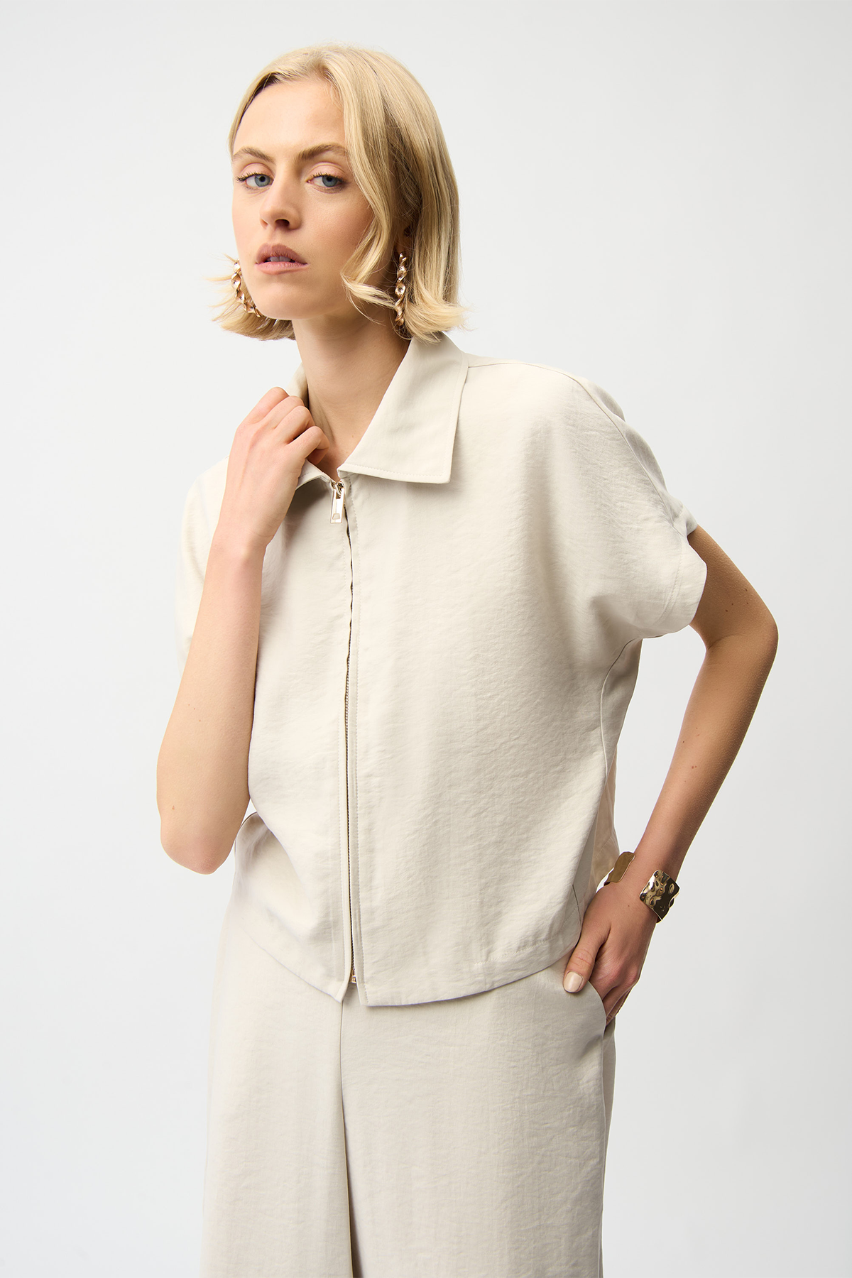 Woman wearing a beige short-sleeve jacket on a white background