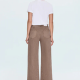 A model shown from the back wearing a white short-sleeve crop top and brown wide-leg cropped pants, paired with beige high-heeled sandals, against a light gray studio background.