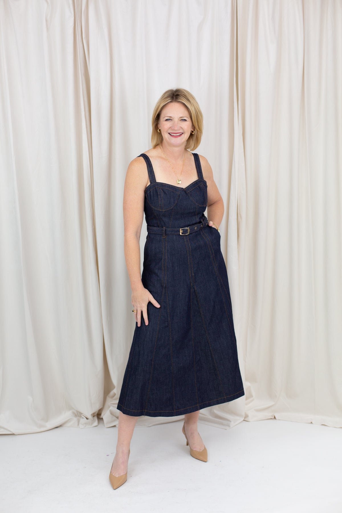 Indigo midi dress with a sweetheart neckline, corset-inspired seams, and a belted waist