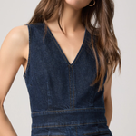 Woman wearing a blue denim dress against a plain background