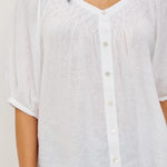 White button-up shirt worn by a person on a plain background