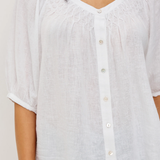 White button-up shirt worn by a person on a plain background