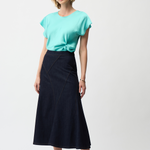 Woman wearing a turquoise top and black skirt on a white background