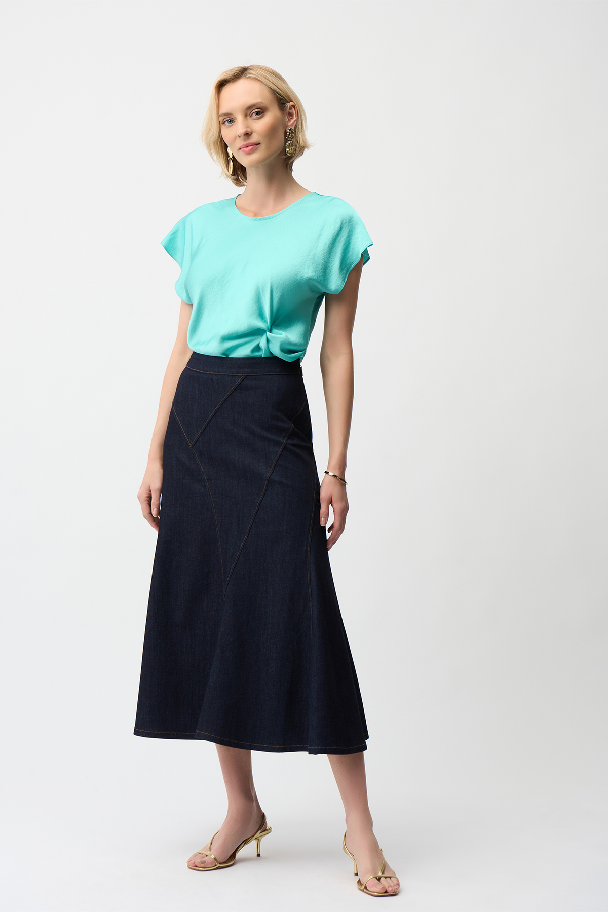 Woman wearing a turquoise top and black skirt on a white background