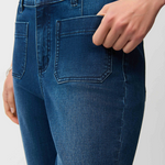 Blue jeans worn by a person on a light gray background