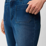Blue jeans worn by a person on a light gray background