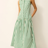 Woman wearing a green and white striped dress on a plain background