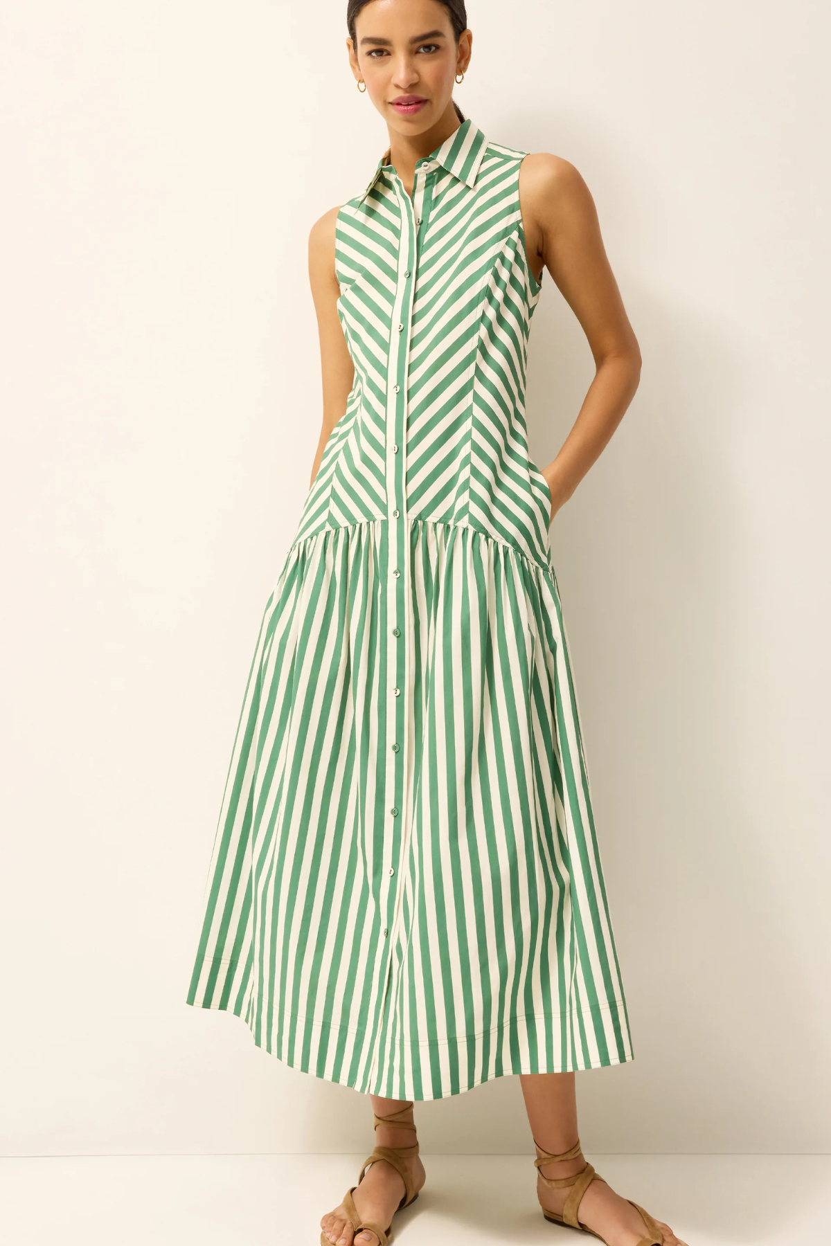 Woman wearing a green and white striped dress on a plain background