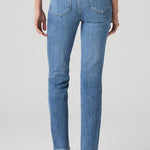 Woman wearing mid-wash straight-leg jeans with a streamlined, classic silhouette.