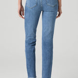 Woman wearing mid-wash straight-leg jeans with a streamlined, classic silhouette.