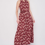 Model wearing a printed sleeveless midi dress featuring a flowing silhouette and vibrant allover pattern.