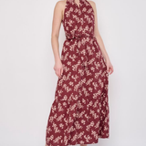 Model wearing a printed sleeveless midi dress featuring a flowing silhouette and vibrant allover pattern.