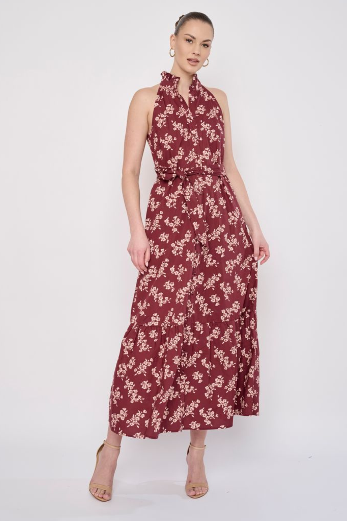 Model wearing a printed sleeveless midi dress featuring a flowing silhouette and vibrant allover pattern.