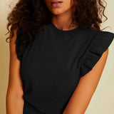 woman black ruffle sleeve top on beige background 